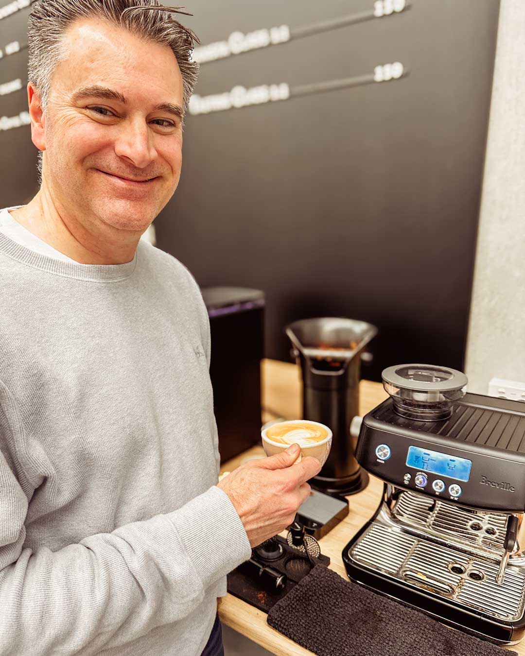 smiling student with his Breville Barista Pro coffee machine in home barista class